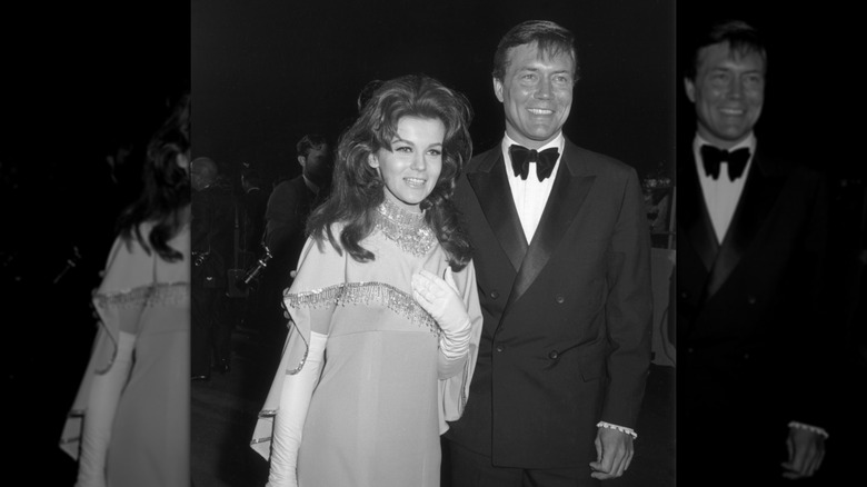 Ann-Margret in an evening gown with a fringe cape and white gloves, next to Roger Smith in a tuxedo
