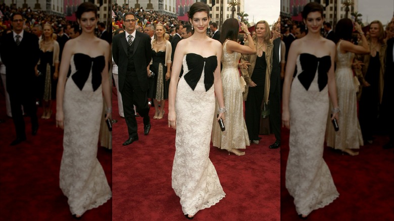 Anne Hathaway wearing a white dress with a black bow on the bust at the 79th Academy Awards