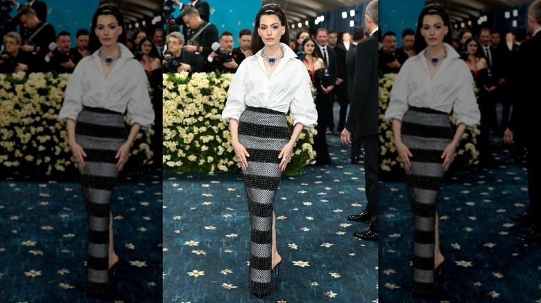 Anne Hathaway wearing a black and silver striped skirt and white shirt at the 2025 Met Gala