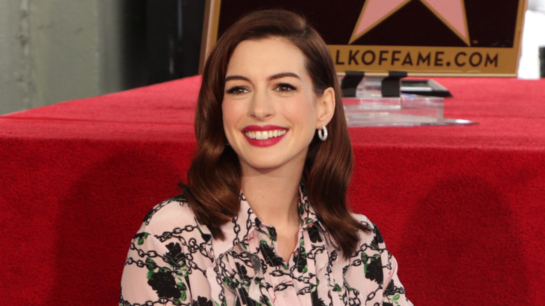 Anne Hathaway poses by her star on the Hollywood Walk of Fame