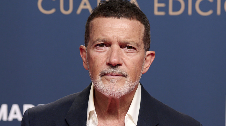 Antonio Banderas posing on the red carpet in a black suit with a white shirt underneath