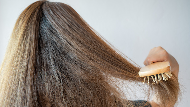 Woman brushing frizzy hair