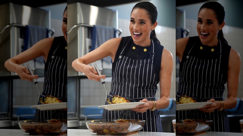 Meghan Markle dishing a casserole serving in Australia