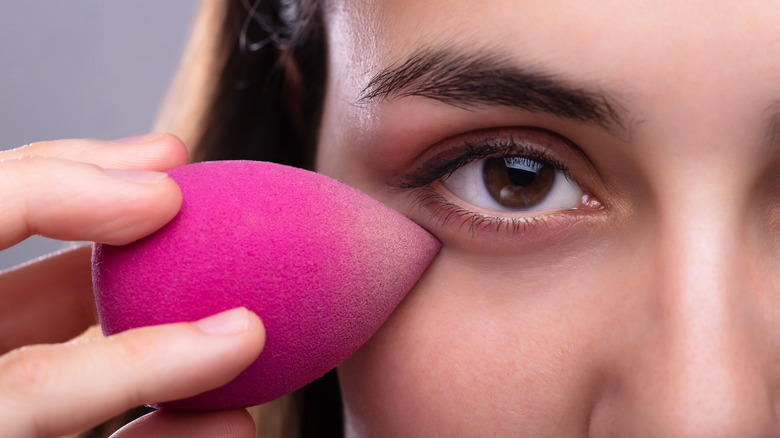 Woman using beauty blender 