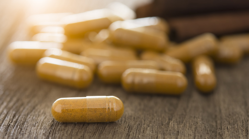 Cinnamon pills on wooden table 