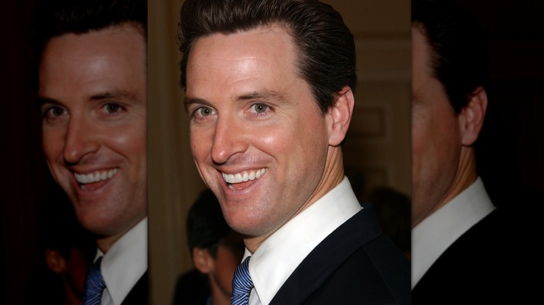 Gavin Newsom in a suit at an event, smiling