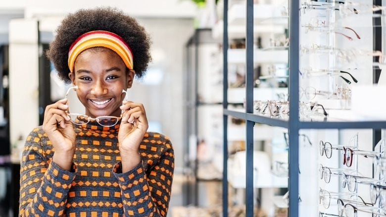 woman in patterned sweater tries on new pair of glasses