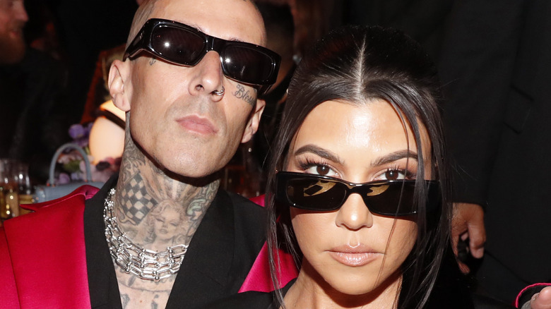 Kourtney Kardashian and Travis Barker pose for a photo. 