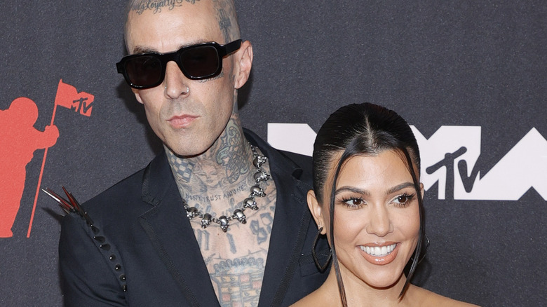 Kourtney kardashian and Travis Barker at an event.