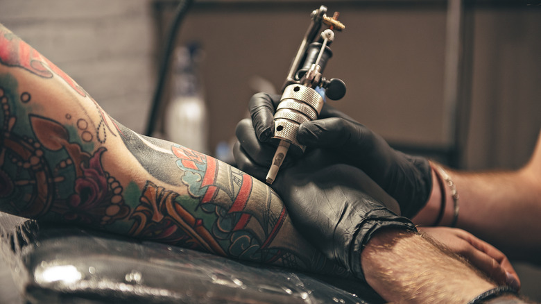 Woman's arm being tattooed