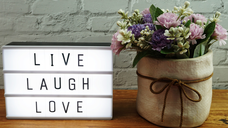 'Live Laugh Love' sign next to flowers