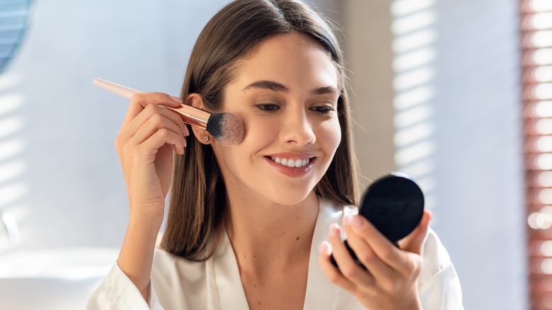 Woman applying blush