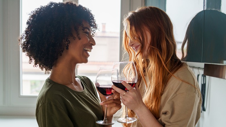 Two women flirting over glasses of wine