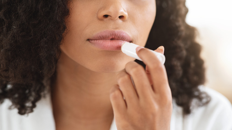 Woman applying lip-balm