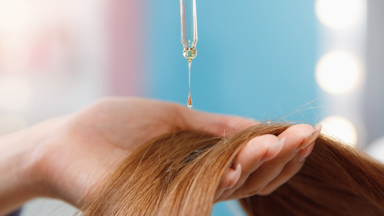 Woman applying hair oil