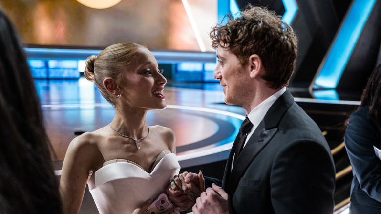 Ethan Slater holding Ethan Slater's hand while they smile at each other