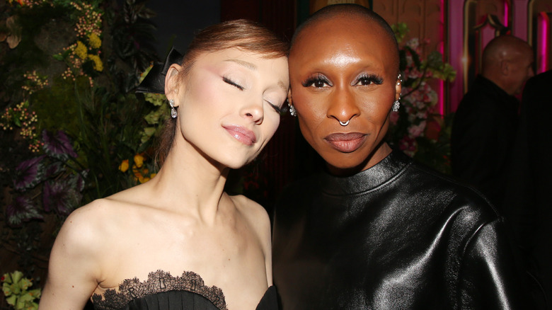 Ariana Grande smiling and touching her forehead to Cynthia Erivo's head