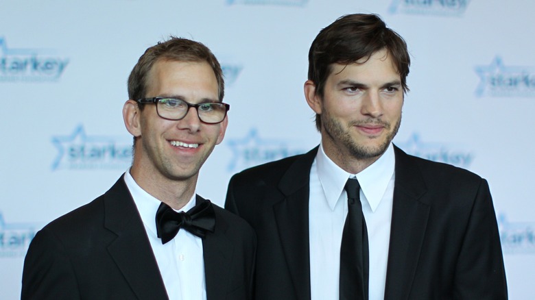 Twins Michael Kutcher and Ashton Kutcher pose at a red carpet event.