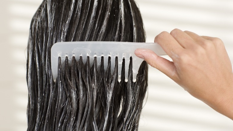 Brushing hair with conditioner