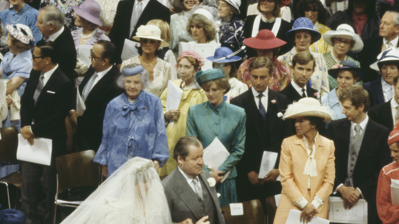 Guests, including Camilla Parker-Bowles, watching Diana walk up the aisle on her wedding day with her father