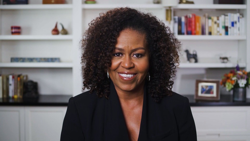 Michelle Obama  in front of her bookshelf