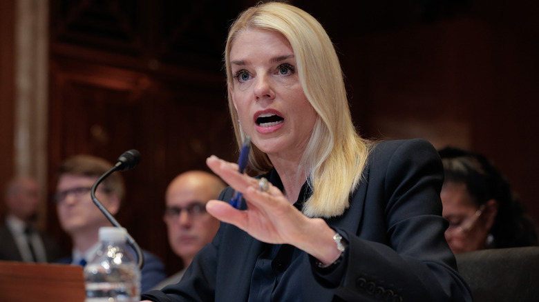Pam Bondi raising her hand while looking aggravated