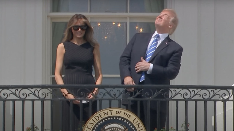 President Trump stares at the eclipse while standing next to his wife