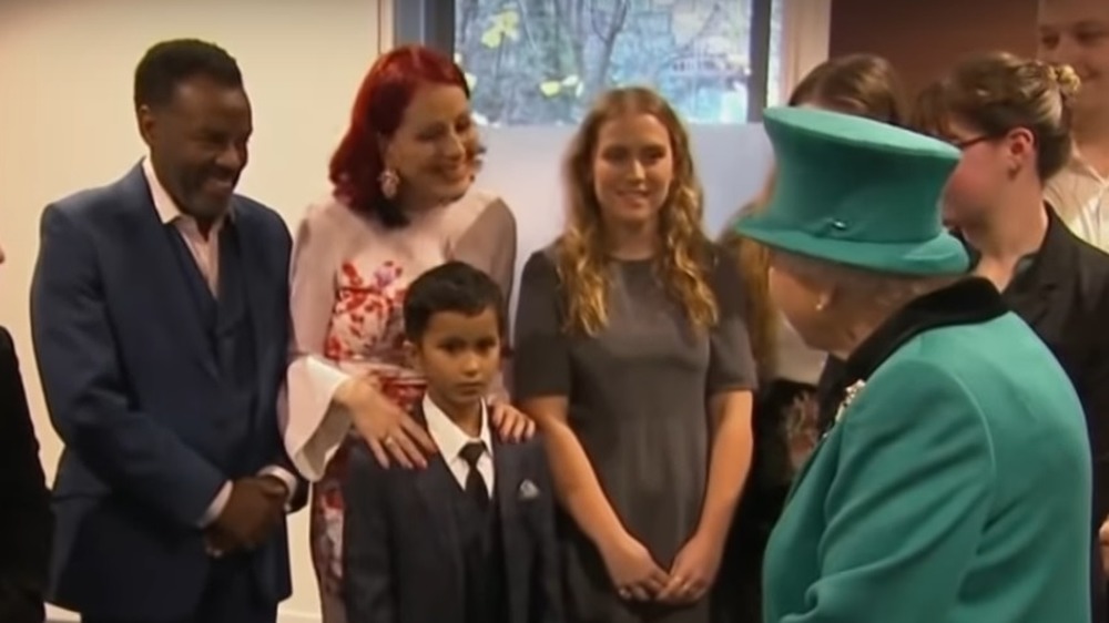 A child crawling away from Queen Elizabeth