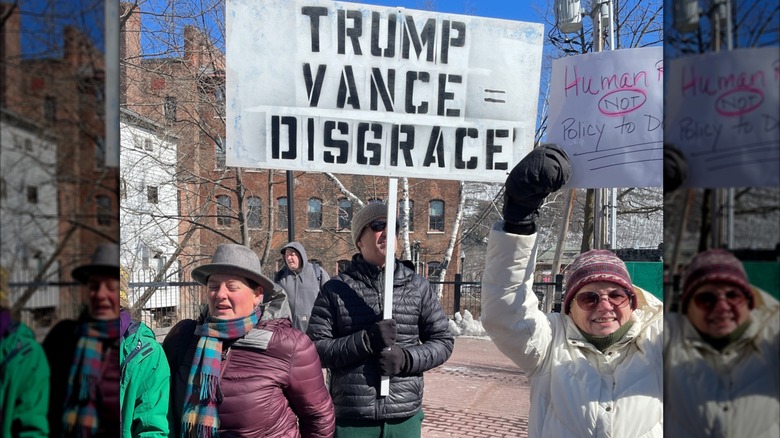 Protesters line up alongside the road where J.D. Vance and his family arrived on their ski trip