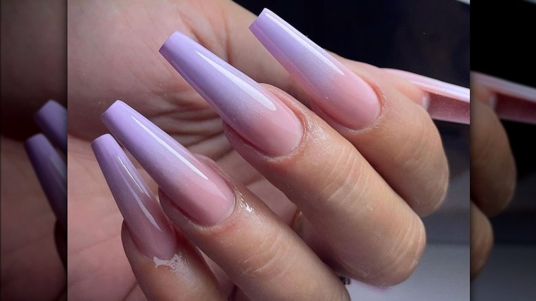 Close-up of a manicure with light purple and light pink ombre nails