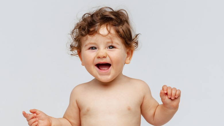 Baby with curly hair laughing