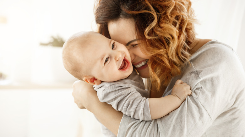 mom holding baby laughing