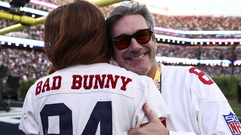 Jon Hamm hugging a woman wearing a Bad Bunny football jersey