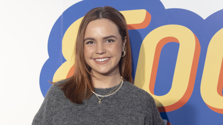 Bailee Madison posing in front of a multicolored background