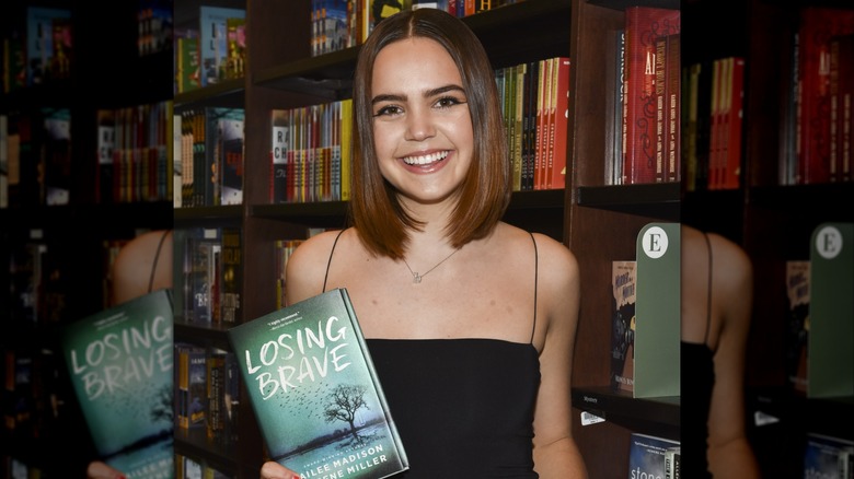 Bailee Madison displaying a copy of her book Losing Brave