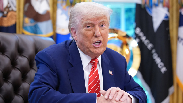 Donald Trump hands folded speaking in Oval Office