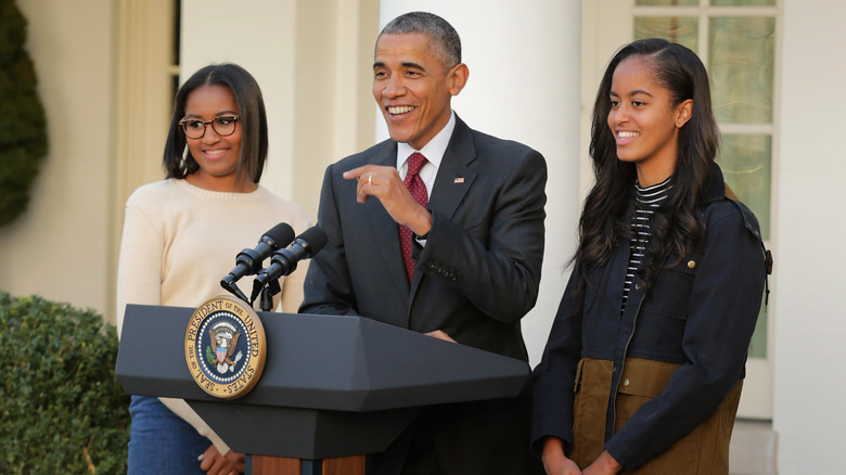Barack Obama giving a speech with his daughters