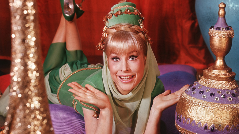 Barbara Eden in costume as Jeannie lying on her stomach and smiling