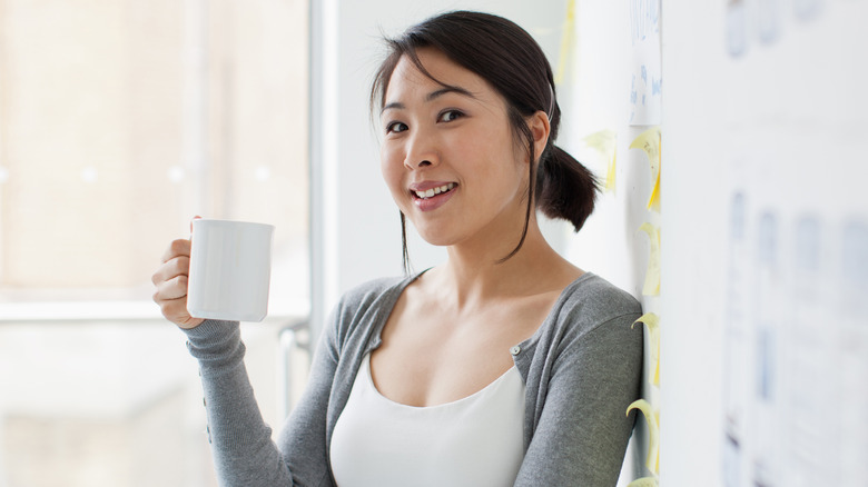 woman drinking coffee at work