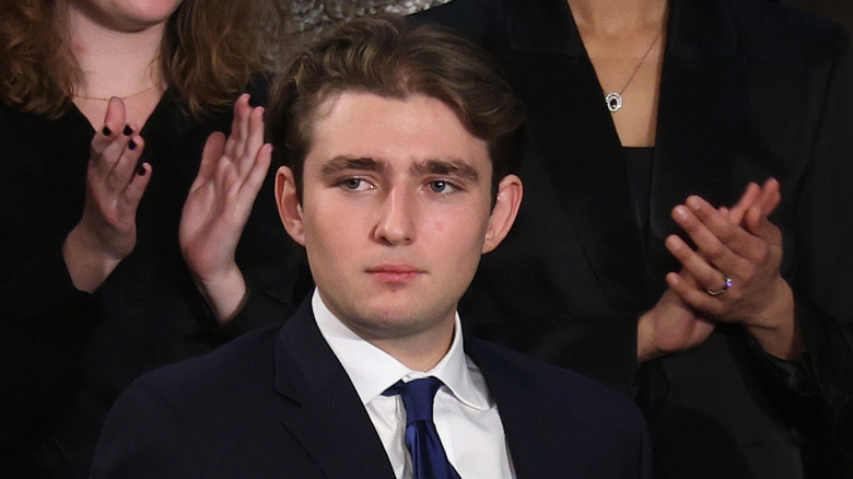 Barron Trump looking sideways with people applauding behind him