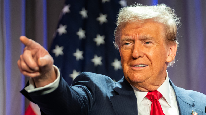 Donald Trump wearing a red tie while pointing