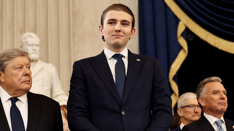 Barron Trump smiling in a navy suit