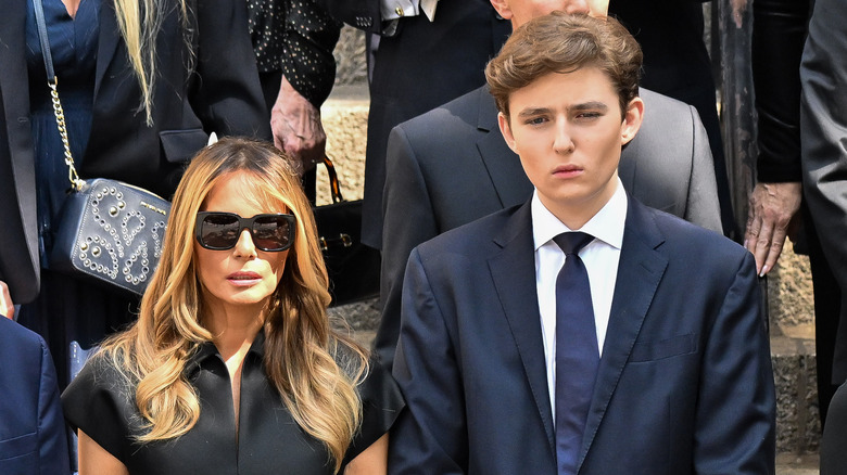 Barron Trump stands beside Melania Trump in formal attire
