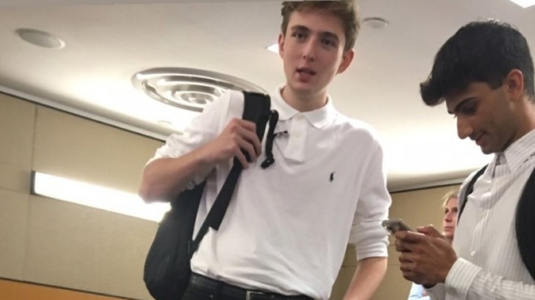 Barron Trump standing beside a classmate holding a phone