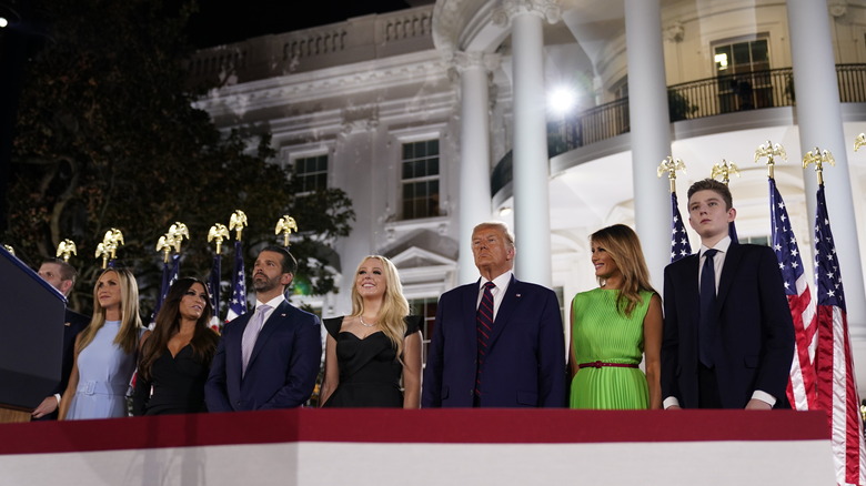 Barron Trump stands with family
