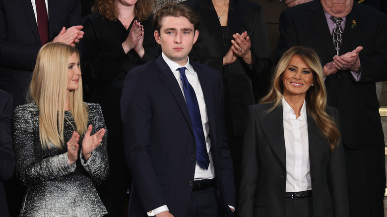 Barron Trump looking serious while standing between Ivanka Trump and Melania Trump