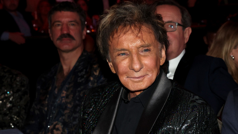 Barry Manilow smiling while sitting at an event in a black jacket