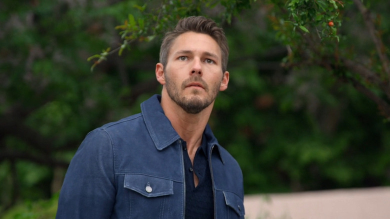 Liam sad as he looks up at Hope and Thomas kissing