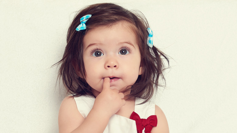 Curious little girl finger in mouth