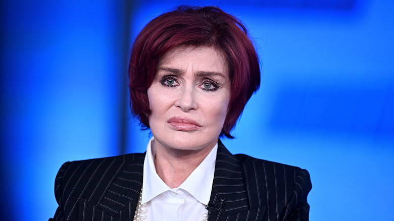 Sharon Osbourne frowning against a blue background